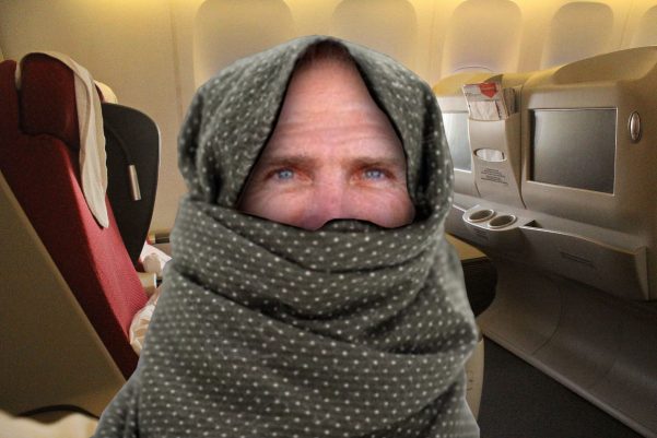 Aajonus Vonderplanitz wearing a mask on a plane