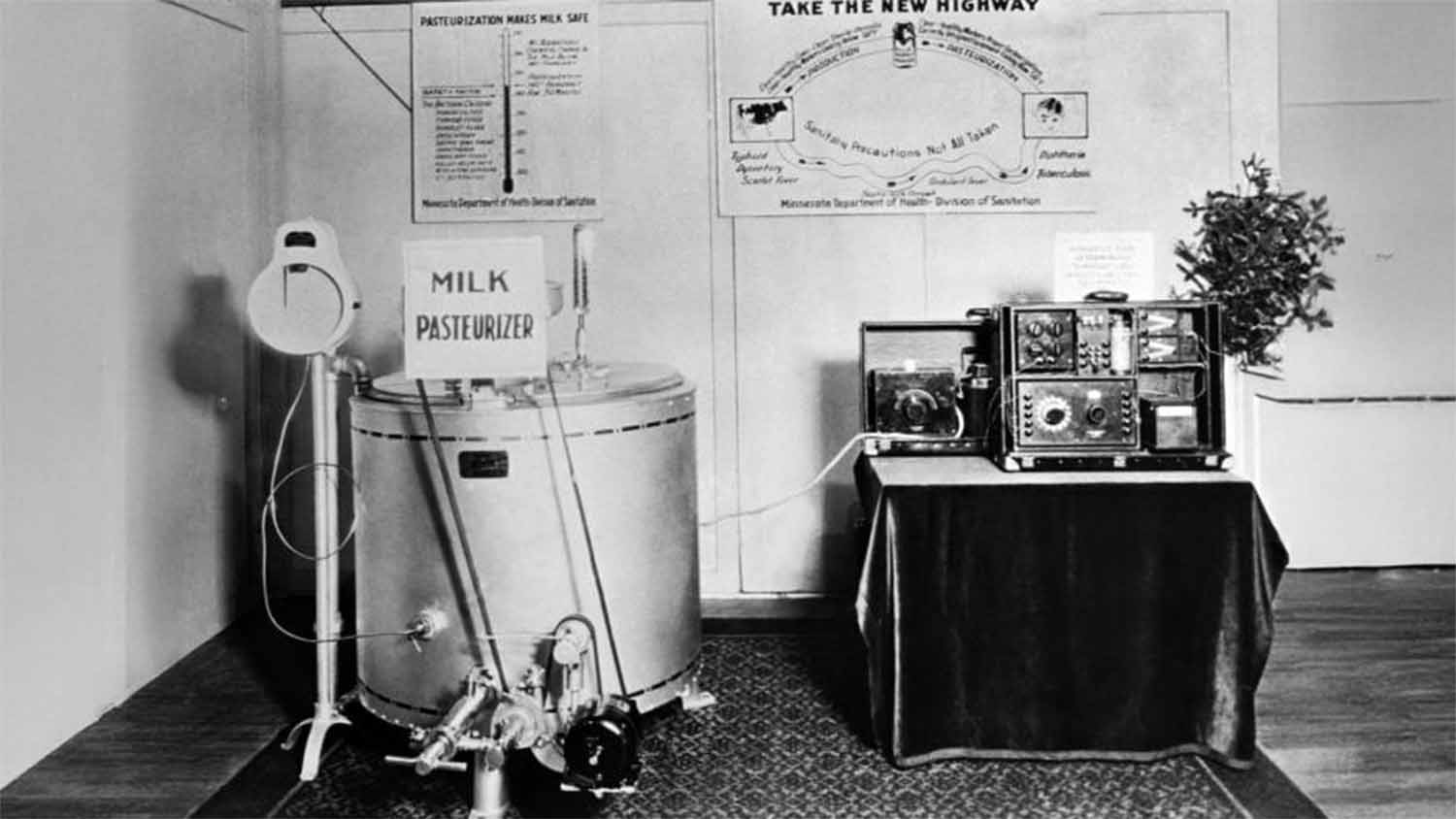 A milk pasteurizer on display at a Minnesota Department of Health public health exhibit, 1929, with informational posters explaining the pasteurization process