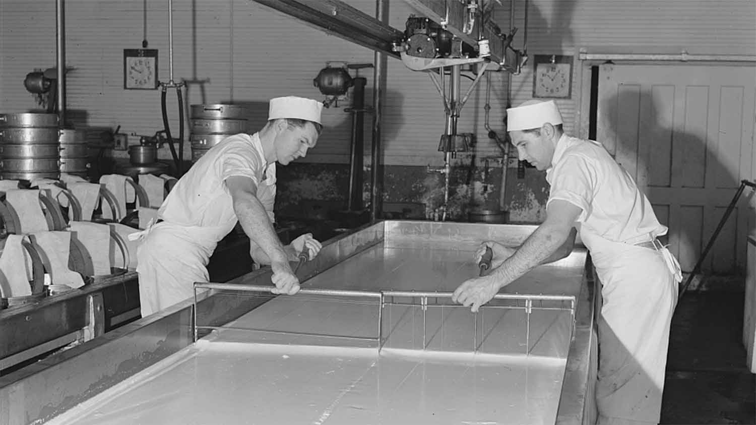 A worker breaking up curdling milk to distribute the lactic ferment starter at the Tillamook cheese plant in Tillamook County, Oregon, October 1941, photographed by Russell Lee for the U.S. Farm Security Administration.